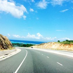 Empty road by landscape against sky