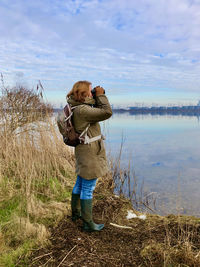 Full length of woman watching over lake against sky