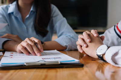 Midsection of business colleagues working on table