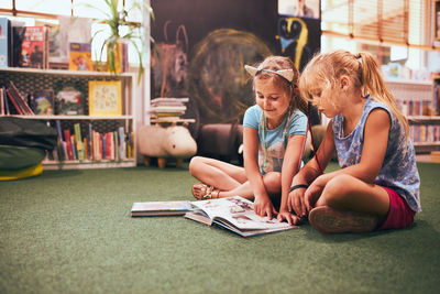 Two primary schoolgirls doing homework in school library. elementary age. back to school