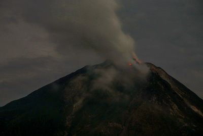 Smoke emitting from volcanic mountain against sky