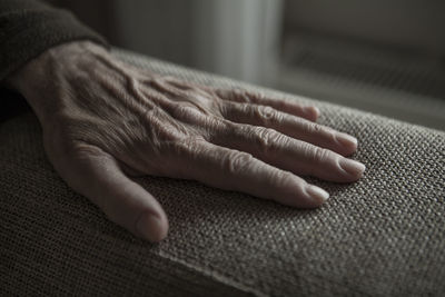 Close-up of person hand on armrest