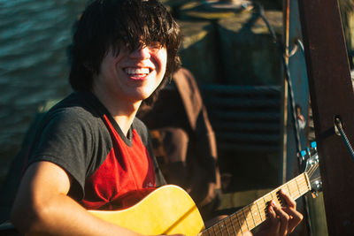 Portrait of smiling man playing guitar