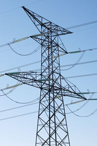 Low angle view of electricity pylon against clear sky