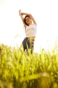 Portrait of young woman standing on field