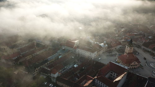 High angle view of townscape against foggy sky in city