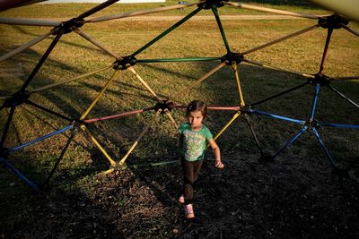 High angle view of girl walking against jungle gym