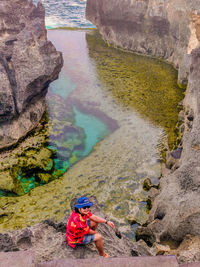 High angle view of man on rock at shore