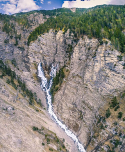 Scenic view of river by mountain against sky