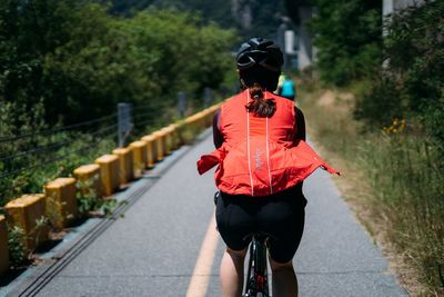 Rear view of man riding bicycle on road