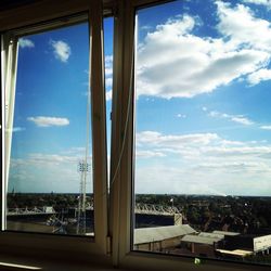 Buildings against sky seen through glass window