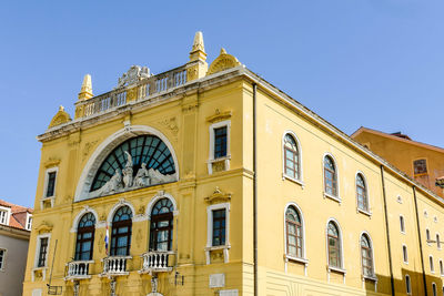 Low angle view of building against clear blue sky