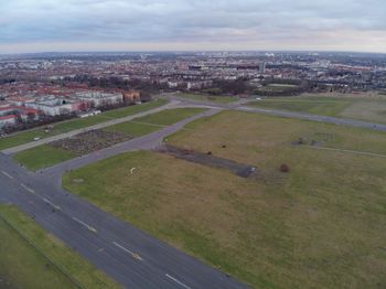 High angle view of field against sky in city