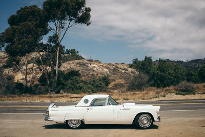 Vintage car on road against sky