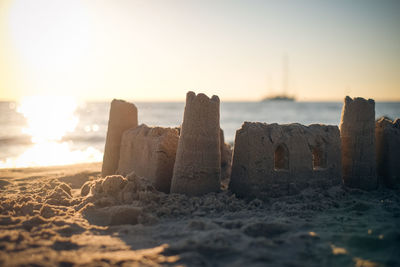 Close-up of beach against sky during sunset