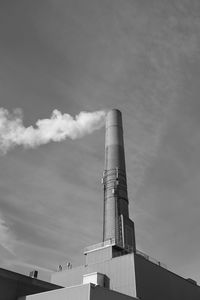 Low angle view of smoke emitting from factory against sky