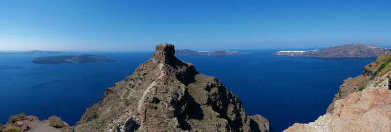 Panoramic view of sea and mountains against blue sky