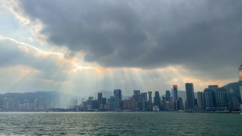 Panoramic view of sea and buildings against sky during sunset