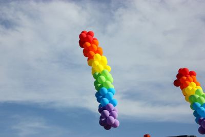 Low angle view of multi colored balloons against sky