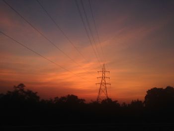 Silhouette electricity pylon against sky during sunset