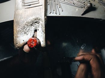 Close-up of hand holding equipment at table in workshop