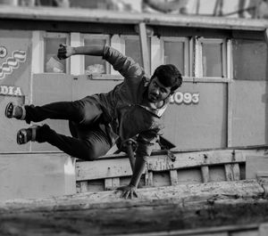 Portrait of man jumping over railing against boat