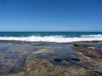 Scenic view of sea against clear blue sky