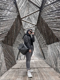 Full length of woman standing on footbridge