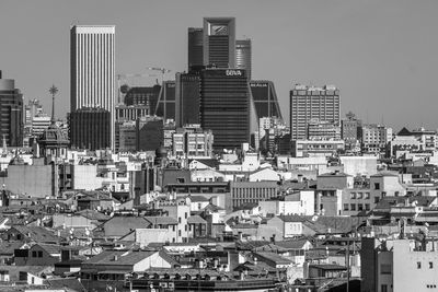 Aerial view of buildings in city against clear sky