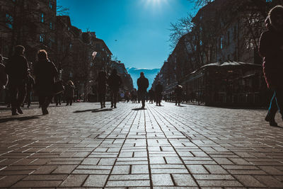 People walking on street in city during sunny day