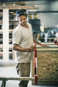 Carpenter making furniture at factory