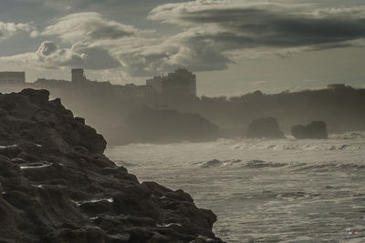 Rocks on sea shore against sky