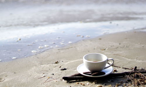 Close-up of coffee cup by water