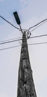 Low angle view of electricity pylon against sky