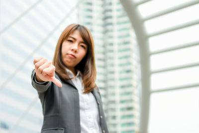 Young businesswoman gesturing while standing in city