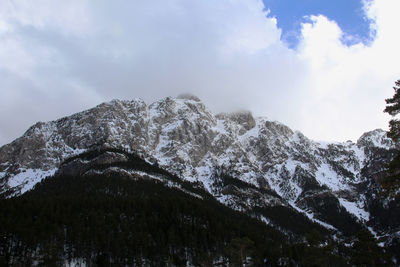 Low angle view of snowcapped mountains against sky