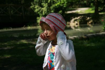 Girl looking away while standing outdoors