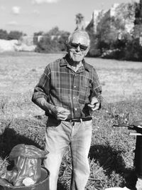 Portrait of man wearing sunglasses standing on field