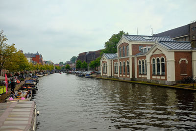 River amidst buildings in city against sky