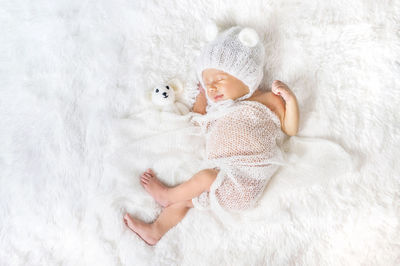 Cute baby girl lying on bed at home