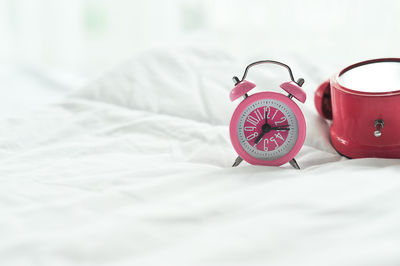 Close-up of alarm clock on bed at home