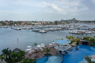  boat harbour with lots of sailboats mored and hotel swimming pool infront