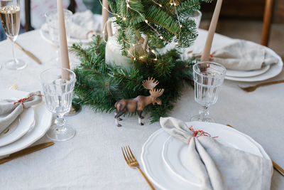 Christmas decor of the festive table, plates, napkins, cutlery, a statuette