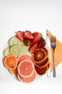 Slices of fresh fruit on plate and cutlery