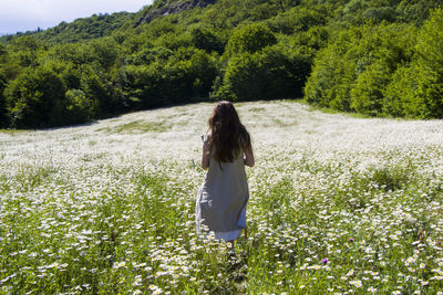 Women with dress in field of daisy flowers during sunlight