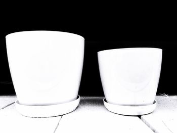 Close-up of empty chairs and table against white wall