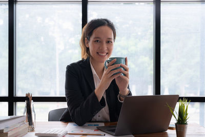 Businesswoman using laptop while sitting at office