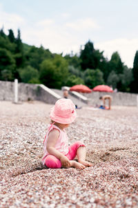 Rear view of girl sitting on land