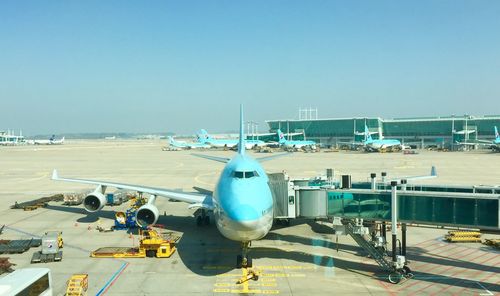 Airplane on airport runway against clear blue sky