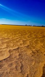 Scenic view of desert against clear blue sky